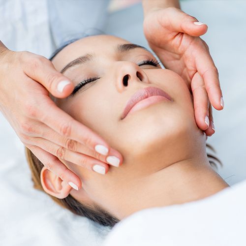 Woman receives a facial treatment at a spa.