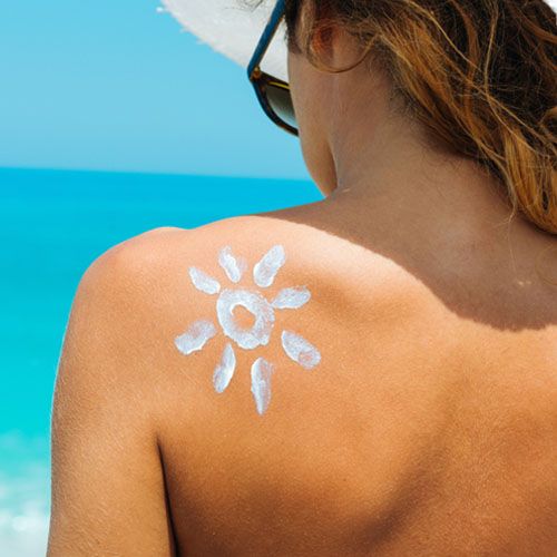 woman with sun-shaped sunscreen drawn on shoulder
