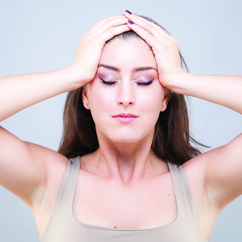 Woman massaging forehead using palms to press into sides of face