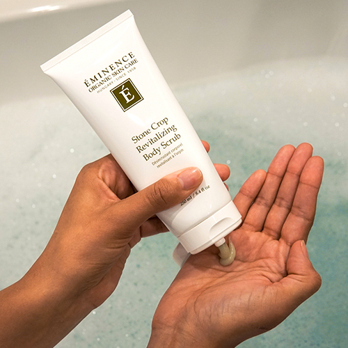 squeezing Stone Crop Revitalizing Body Scrub into hand 