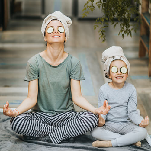 Mom and daughter meditating for an at home spa day