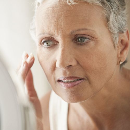 Mature woman demonstrating skin care routine