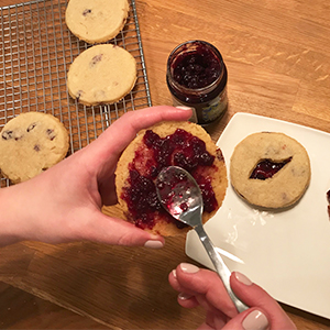 Spreading jam on one organic sugar cookie